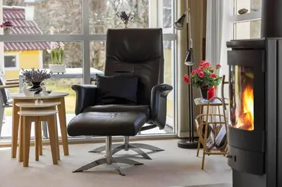 a black chair in a living room with a fireplace at JB404-Fjerritslev-Jesper-Jensensvej-9 in Slettestrand
