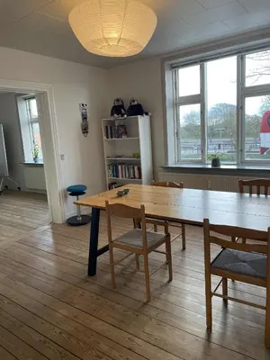 a dining room with a wooden table and chairs at Lejlighed midt i Thisted in Thisted