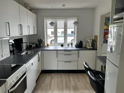 a kitchen with white cabinets and black counter tops at Idyllic Countryside Farm with Horseback Riding in Nibe