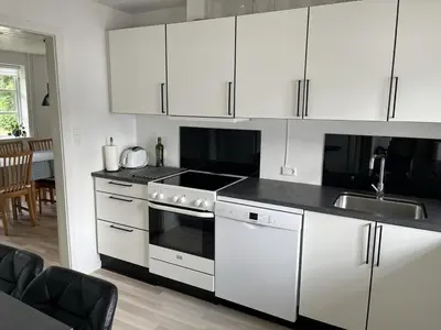 a kitchen with white cabinets and a stove top oven at Idyllic Countryside Farm with Horseback Riding in Nibe