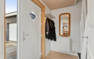 a hallway with a door and a mirror at Nice Home In Thyborøn With Wifi in Thyborøn