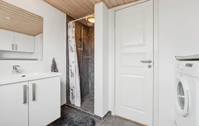 a bathroom with a shower and a white door at Nice Home In Thyborøn With Wifi in Thyborøn