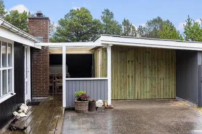 a garage with a wooden door next to a house at 741-Thisted-Klemsvej-29 in Nørre Vorupør