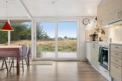 a kitchen with a table and a large sliding glass door at 741-Thisted-Klemsvej-29 in Nørre Vorupør