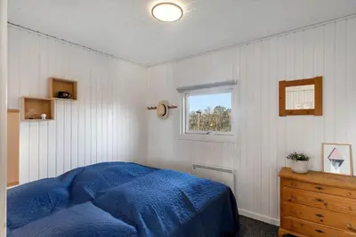 a bedroom with a blue bed and a window at 822-Harboore-Neerlandiavej-138 in Harboør