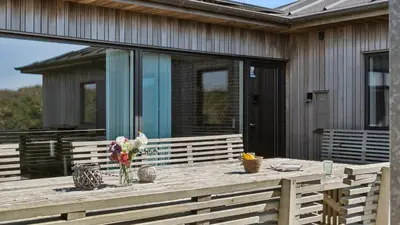 a wooden deck with a vase of flowers on it at Villavilla 607 - Vorupør, Nordjylland in Thisted