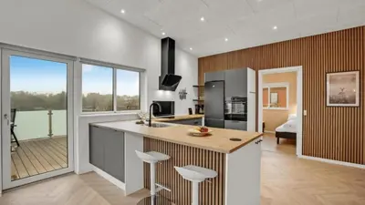 a kitchen with a large island with bar stools at Villavilla 603 - Hostrup Strand, Limfjorden in Spottrup