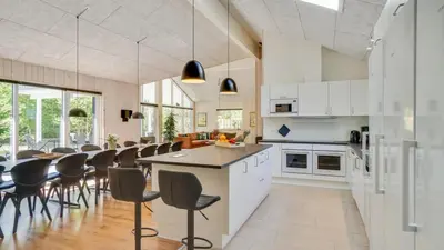 a kitchen and dining room with a table and chairs at Villavilla 494 - Thorup Strand, Nordjylland in Fjerritslev