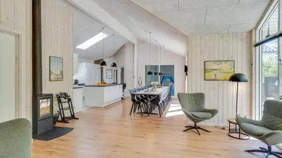 a kitchen and living room with a table and chairs at Villavilla 494 - Thorup Strand, Nordjylland in Fjerritslev
