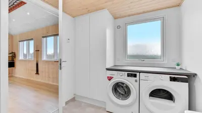 a laundry room with a washing machine and a window at Villavilla 539 - Hostrup Strand, Limfjorden in Spottrup