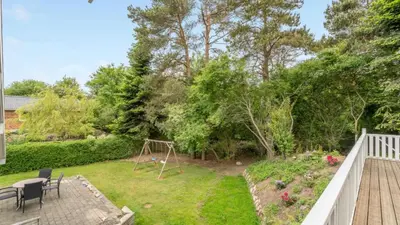a backyard with a garden with a wooden deck at Villavilla 373 - Glyngøre, Limfjorden in Roslev