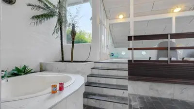 a bathroom with a tub and a palm tree at Villavilla 373 - Glyngøre, Limfjorden in Roslev