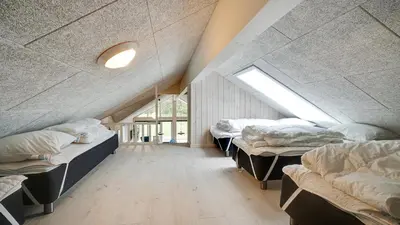 a attic room with three beds and a window at Villavilla 429 - Hostrup Strand, Limfjorden in Spottrup