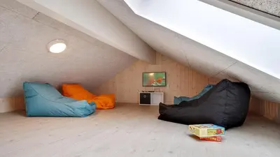 a attic room with two bean bags and a tv at Villavilla 429 - Hostrup Strand, Limfjorden in Spottrup