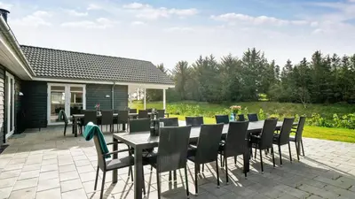 a patio with a table and chairs on a patio at Villavilla 429 - Hostrup Strand, Limfjorden in Spottrup