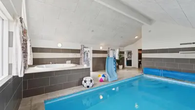 a bathroom with a swimming pool and a bath tub at Villavilla 404 - Hostrup Strand, Limfjorden in Spottrup