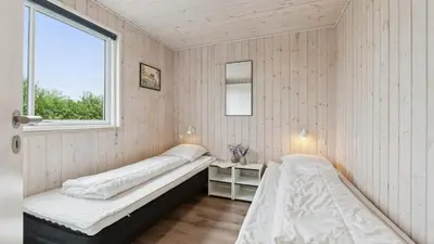 two beds in a room with a window at Villavilla 404 - Hostrup Strand, Limfjorden in Spottrup