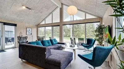 a living room with couches and a table and chairs at Villavilla 431 - Hostrup Strand, Limfjorden in Spottrup