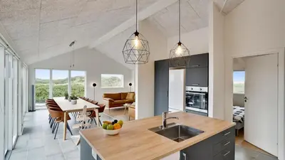 a kitchen with a sink and a table in a room at Villavilla 514 - Grønhøj, Nordjylland in Løkken
