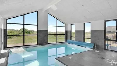 a swimming pool with windows in a building at Villavilla 909 - Blokhus, Nordjylland in Blokhus