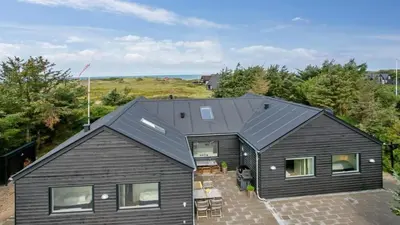 an aerial view of a black house with a patio at Villavilla 411 - Blokhus, Nordjylland in Blokhus