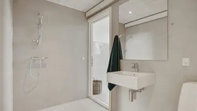 a white bathroom with a sink and a shower at Villavilla 411 - Blokhus, Nordjylland in Blokhus