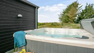 a jacuzzi tub sitting on the side of a building at Villavilla 411 - Blokhus, Nordjylland in Blokhus