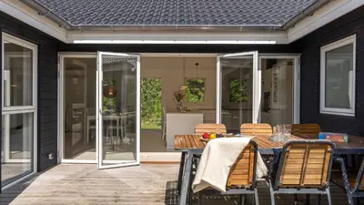 a patio with a table and chairs on a house at Villavilla 691 - Blokhus, Nordjylland in Blokhus