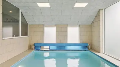 a swimming pool in a room with a large window at Villavilla 637 - Vorupør, Nordjylland in Snedsted