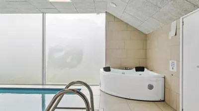 a bathroom with a bath tub and a sink at Villavilla 637 - Vorupør, Nordjylland in Snedsted