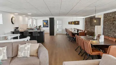 a dining room and living room with tables and chairs at Villavilla 680 - Blokhus, Nordjylland in Blokhus