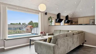 a living room with a couch and a large window at Villavilla 686 - Hostrup Strand, Limfjorden in Spottrup