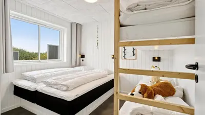 a bedroom with two bunk beds and a window at Villavilla 686 - Hostrup Strand, Limfjorden in Spottrup