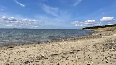 a sandy beach with the ocean on a cloudy day at Villavilla 686 - Hostrup Strand, Limfjorden in Spottrup