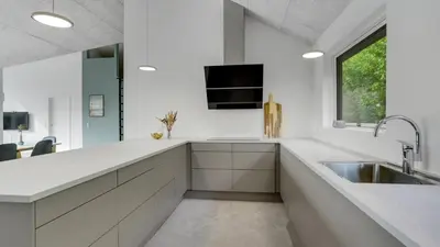 a kitchen with white counters and a sink and a window at Villavilla 692 - Blokhus, Nordjylland in Blokhus