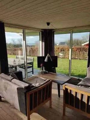 a living room with a couch and a table at Peaceful Holiday Home With Pool Summer And Spa in Farsø