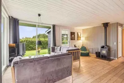 a living room with a couch and a fireplace at Peaceful Holiday Home With Pool Summer And Spa in Farsø