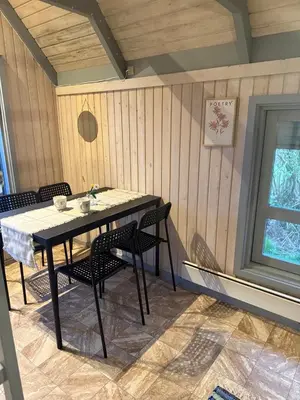 a table in a room with chairs and a window at Bovbjerg Camping in Lemvig