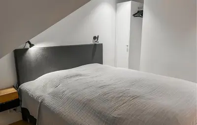 a bedroom with a white bed with a black headboard at Amazing Apartment In Blokhus With House A Panoramic View in Blokhus