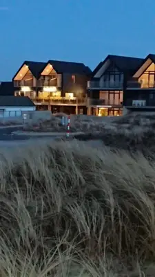 a house with a field of grass in front of it at Hotel og Restaurant Havbadet in Thisted