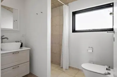a bathroom with a toilet and a sink and a window at BL1150-Saltum-Tolhoj-46 in Saltum