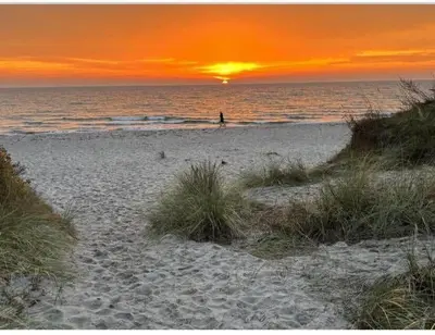 a person walking on the beach at sunset at BL1149-Blokhus-Paa-Bakken-12 in Blokhus