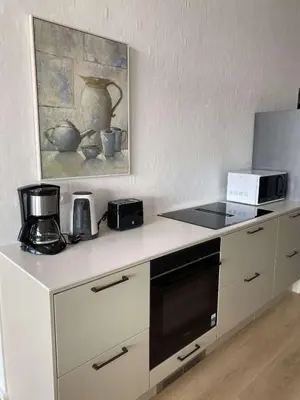 a kitchen with a counter with a stove and a microwave at Luxury cottage close to the beach in Løkken