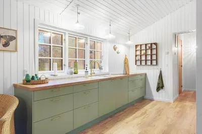 a large kitchen with green cabinets and windows at BL1148-Blokhus-Havorns-Alle-6 in Blokhus