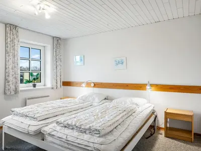 two beds in a bedroom with white walls at Holiday Home Siljana - 200m from the sea by Interhome in Lemvig
