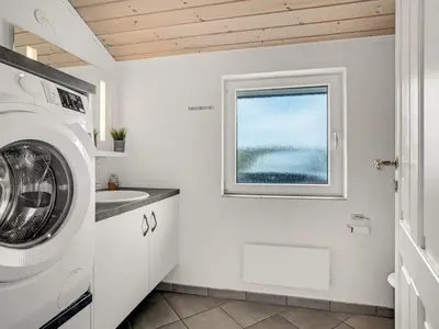 a laundry room with a washing machine and a window at Holiday Home Nimrod - 70m from the sea by Interhome in Thisted