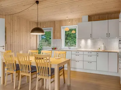 a kitchen with a dining room table and chairs at Holiday Home Ovine - 900m from the sea by Interhome in Thisted
