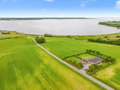 an aerial view of a house in a field next to a lake at Holiday Home Erja - 300m to the fjord by Interhome in Roslev