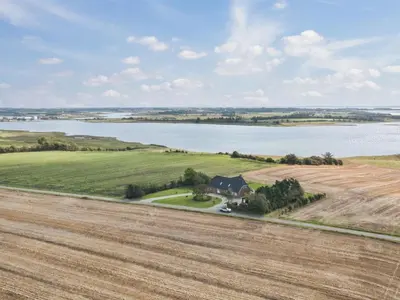 an aerial view of a farm with a field and a lake at Holiday Home Fridhild - 150m to the fjord by Interhome in Redsted