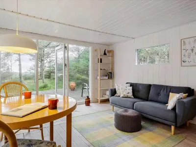 a living room with a blue couch and a table at Holiday Home Patti - 700m from the sea by Interhome in Blokhus